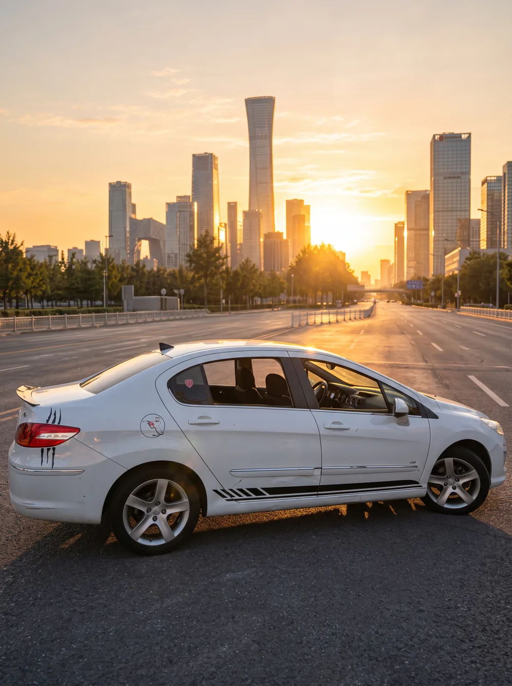 A silver car on a city avenue at sunset